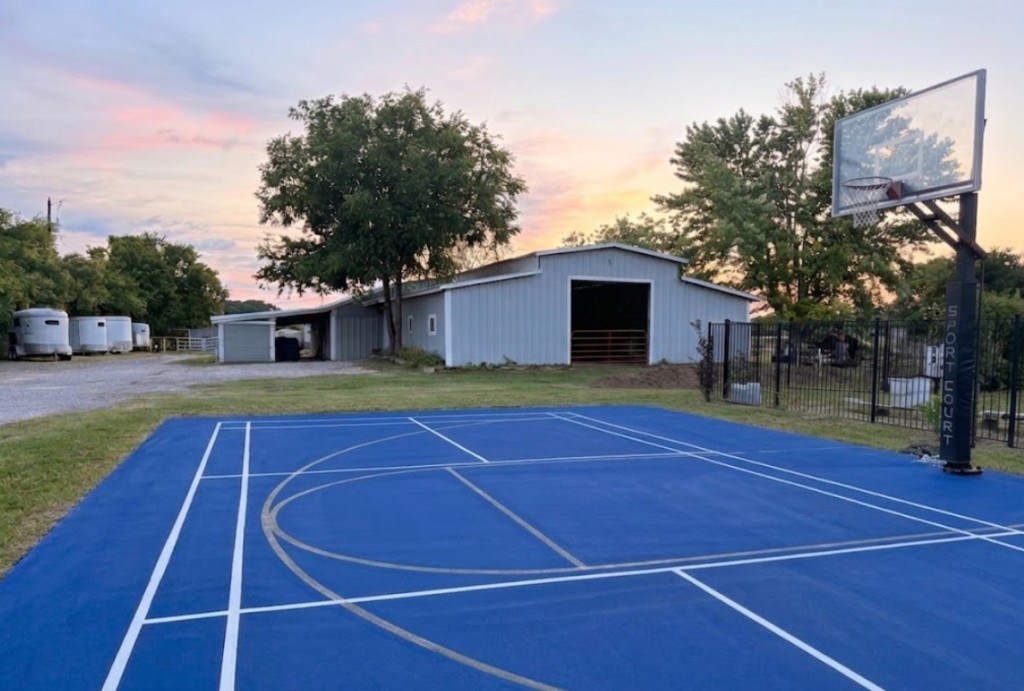 Outdoor sport court with basketball hoop at sunset
